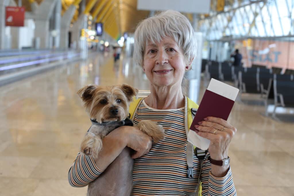 Woman Holding Pet Passport and Dog in Airport