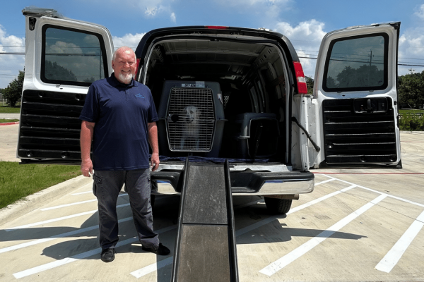 Picture of the pet taxi services van with a driver and a dog in a crate